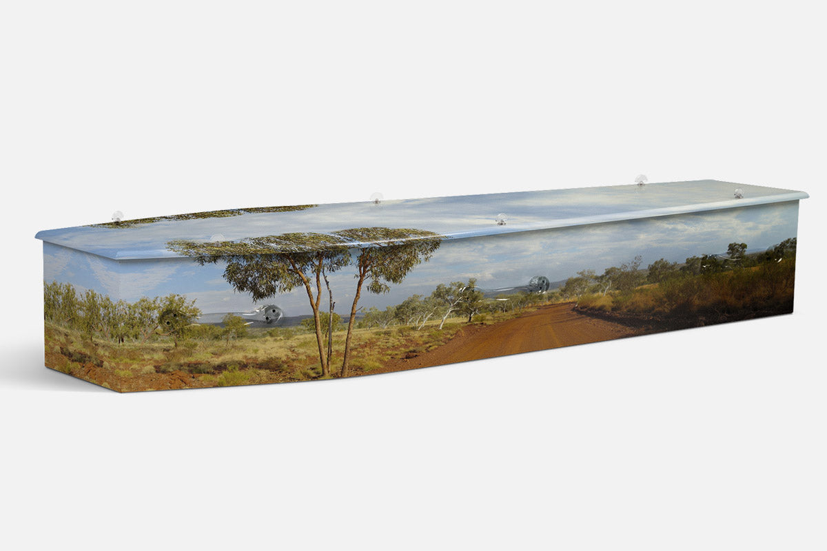 Australian Outback coffin in a red dirt road through scrub and eucalypts under a wide sky
