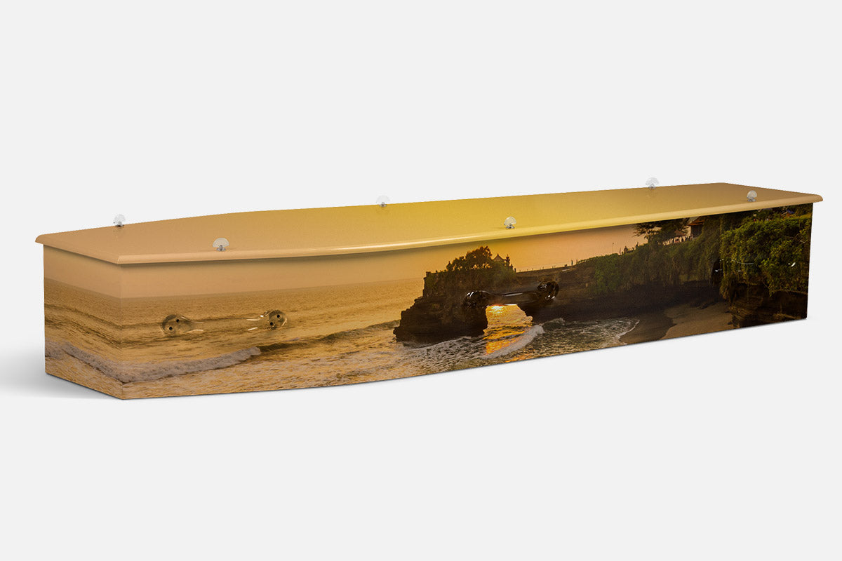 Bali Sunset coffin in a golden sunset over the ocean with a rock arch temple silhouette