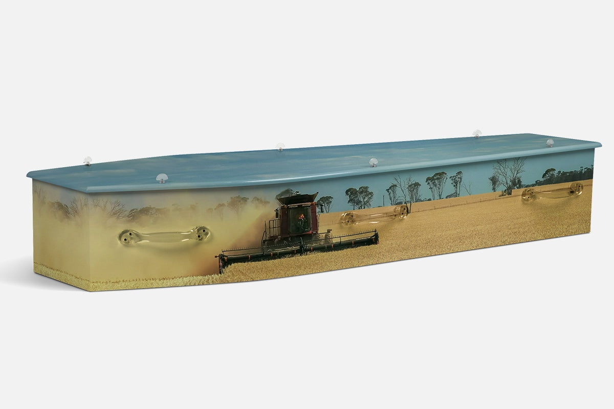 Combine Harvesting coffin in a photographic scene of a red combine harvester working a golden wheat field