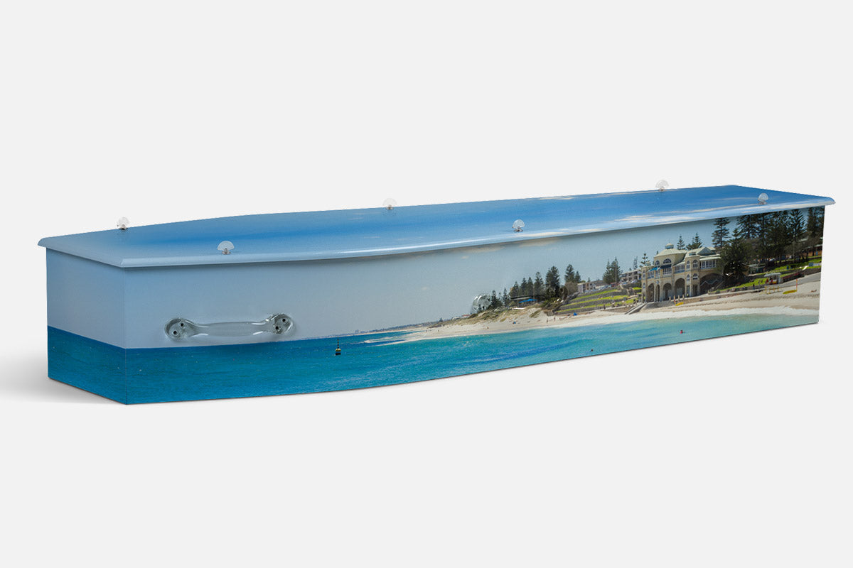 Cottesloe Beach coffin in a photographic view of a seaside building, palm trees and turquoise shoreline