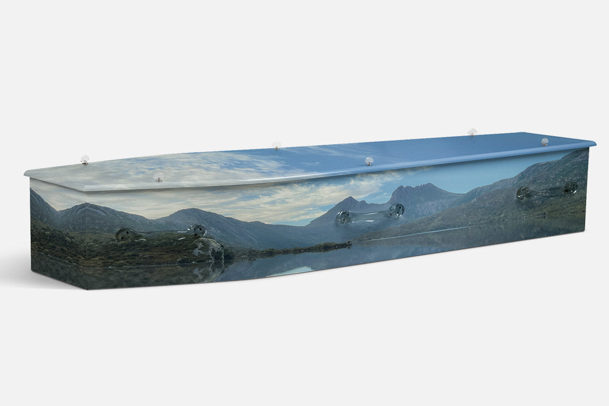 Cradle Mountain coffin in a photographic scene of blue mountain peaks reflected in a still lake