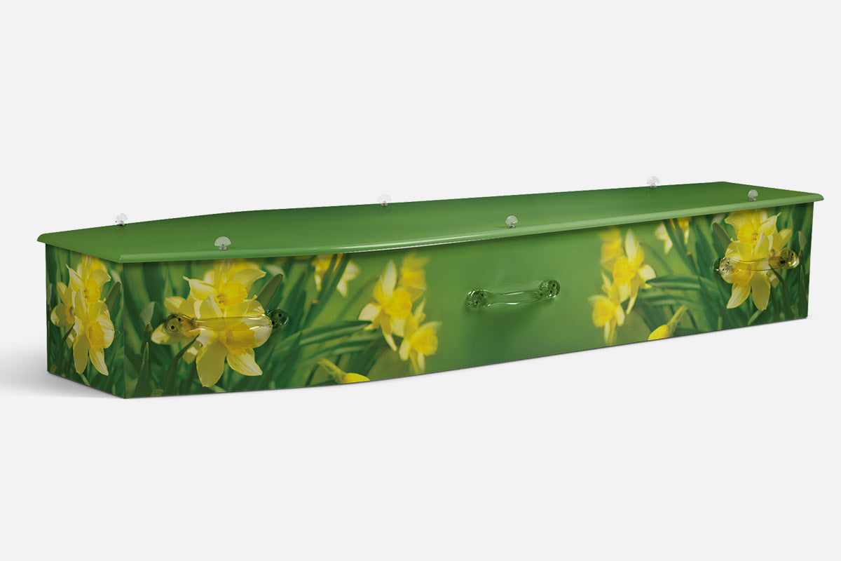 Daffodil Delight coffin in bright yellow daffodils against a green garden backdrop