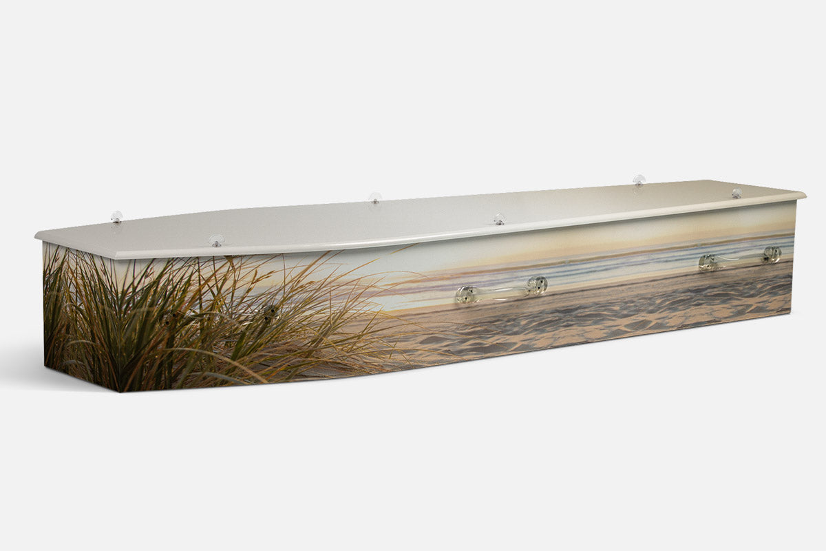 Gold Coast Beach coffin in a photographic dune scene with golden grass and a hazy sunlit shoreline