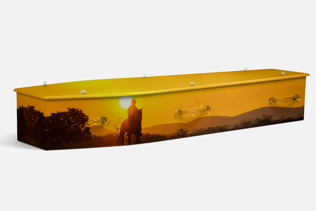 Jackaroo coffin showing a silhouetted rider on horseback at golden sunset with trees and hills