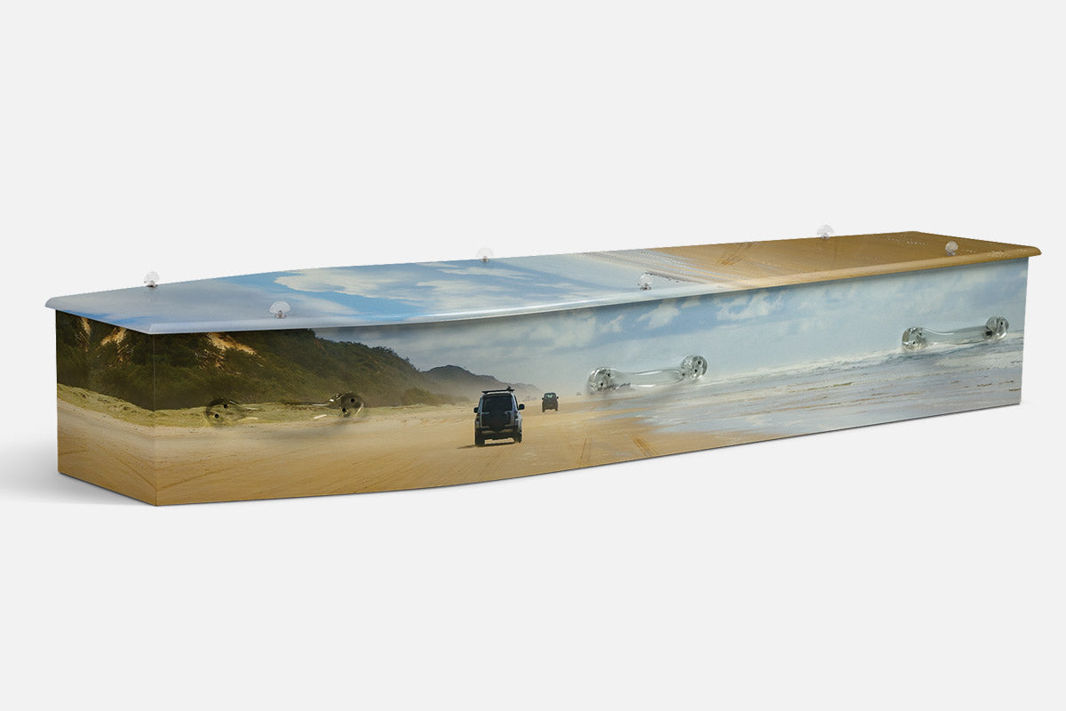 Kgari coffin in a photographic beach scene with four wheel drives on wide sand and dunes