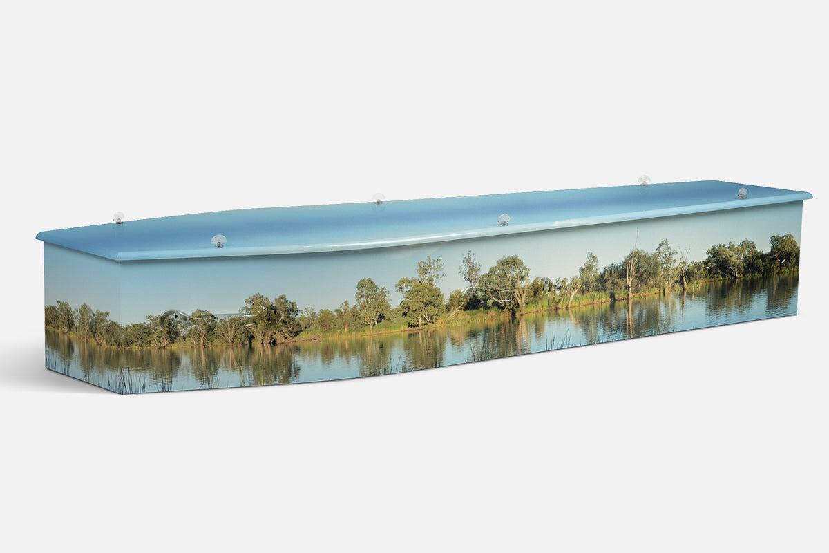 Murray River coffin in a photographic scene of pale cliffs and gum trees along a golden lit bend