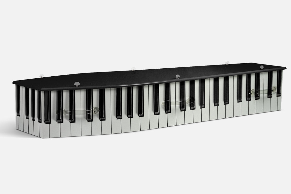 Piano coffin wrapped in black and white piano keys along the sides and lid edge