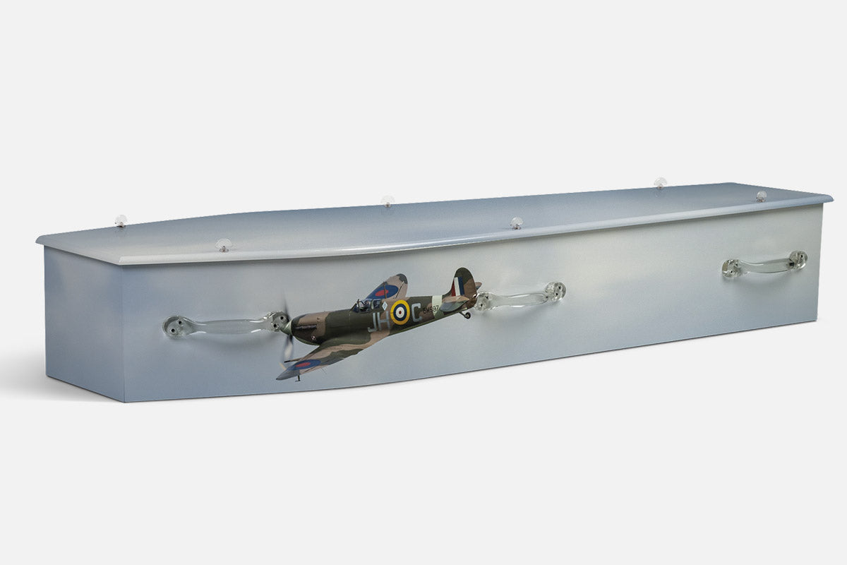 Spitfire coffin in a pale sky background with a photographic camouflage Spitfire aeroplane and roundel markings