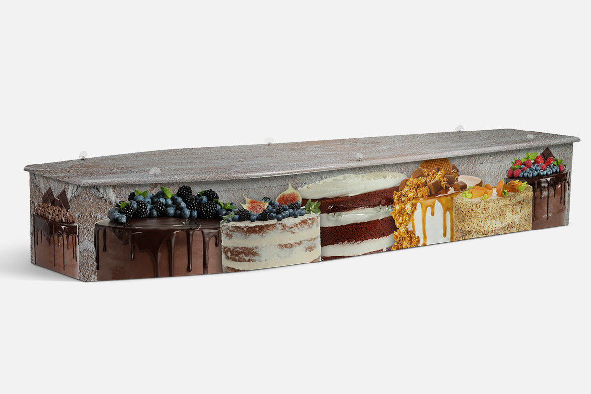 The Baker coffin in a photographic row of cakes with chocolate drip, red velvet, caramel and berry toppings