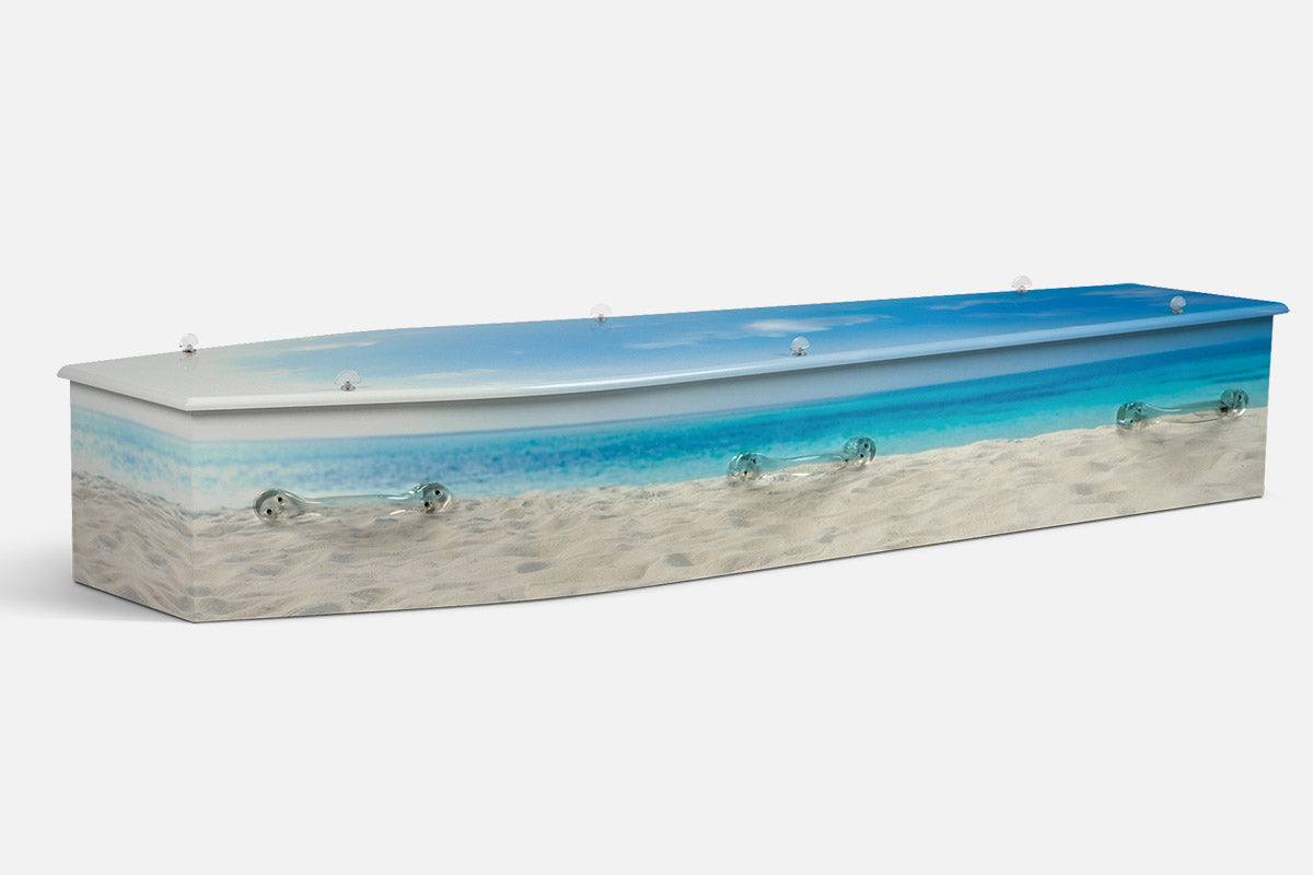 The Beach coffin in a photographic close up of white sand, pale footprints and turquoise water