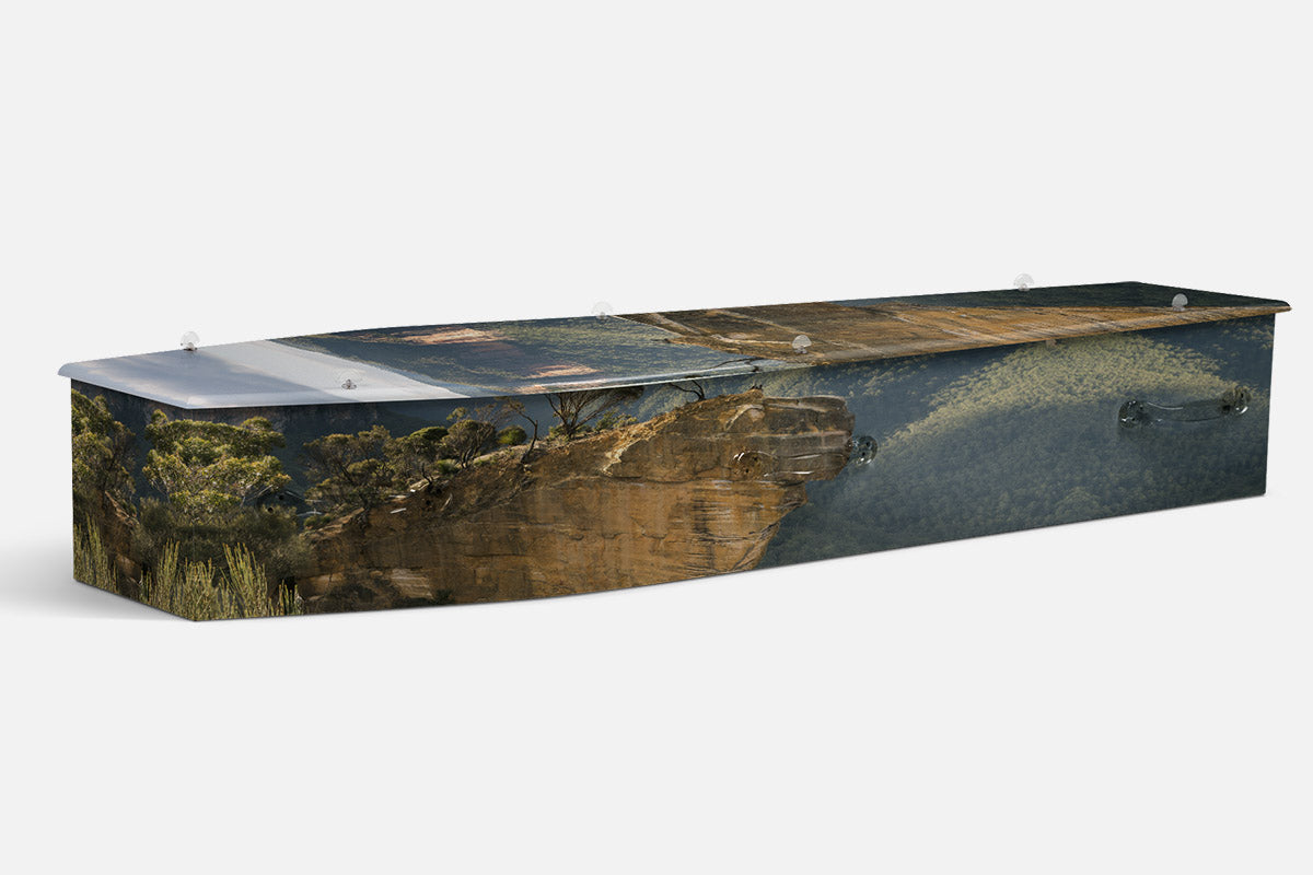 The Climber coffin in a photographic misty mountain valley with a figure standing on a rocky cliff edge