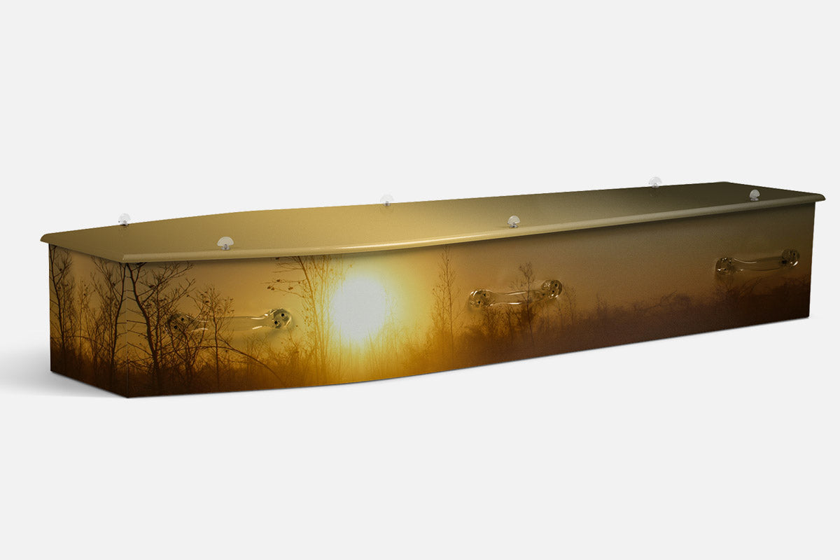 The Kimberley Sunrise coffin in a photographic scene of silhouetted trees against a golden misty sunrise