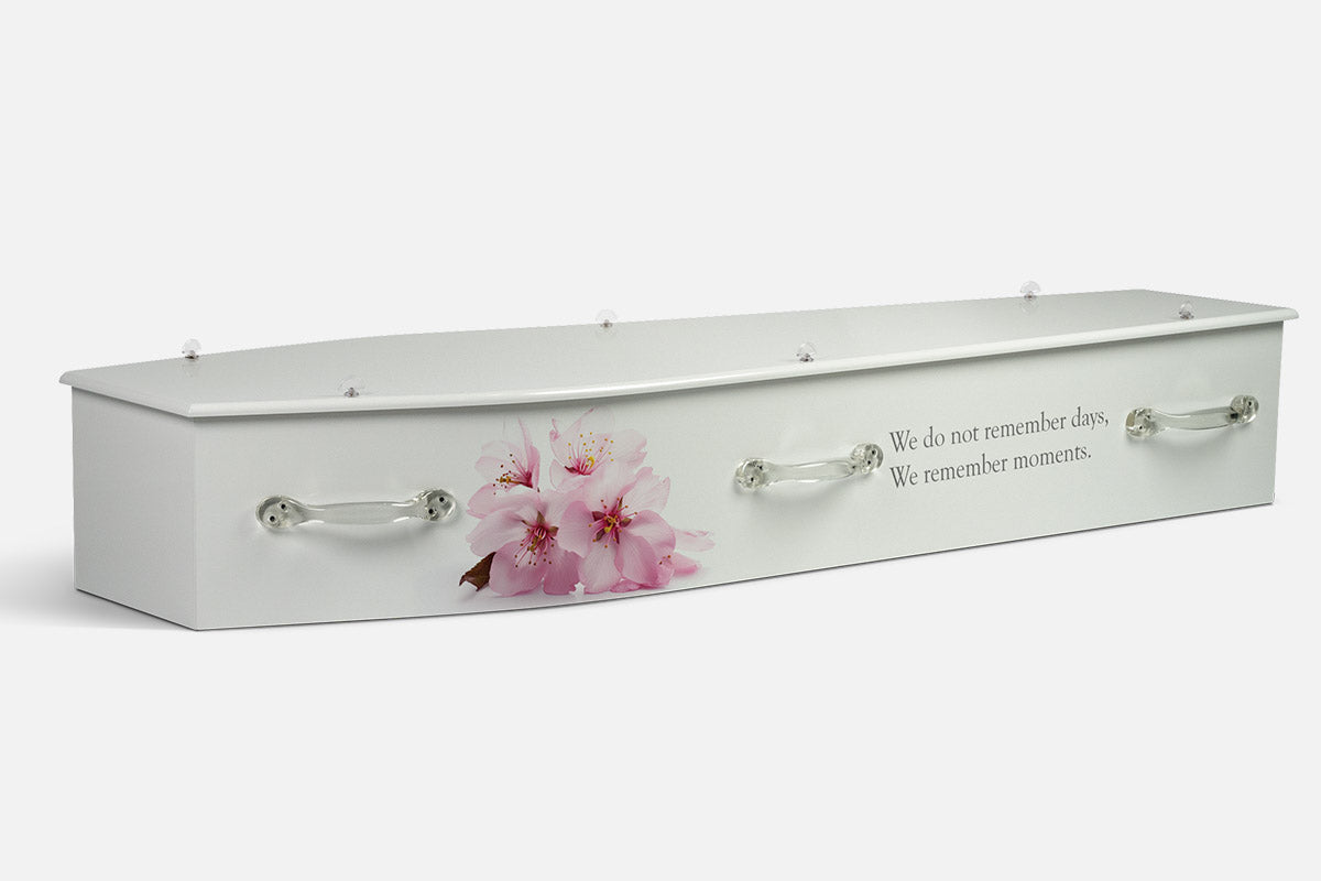 White Grace coffin in plain white with a cluster of pink cherry blossoms and a printed memory quote